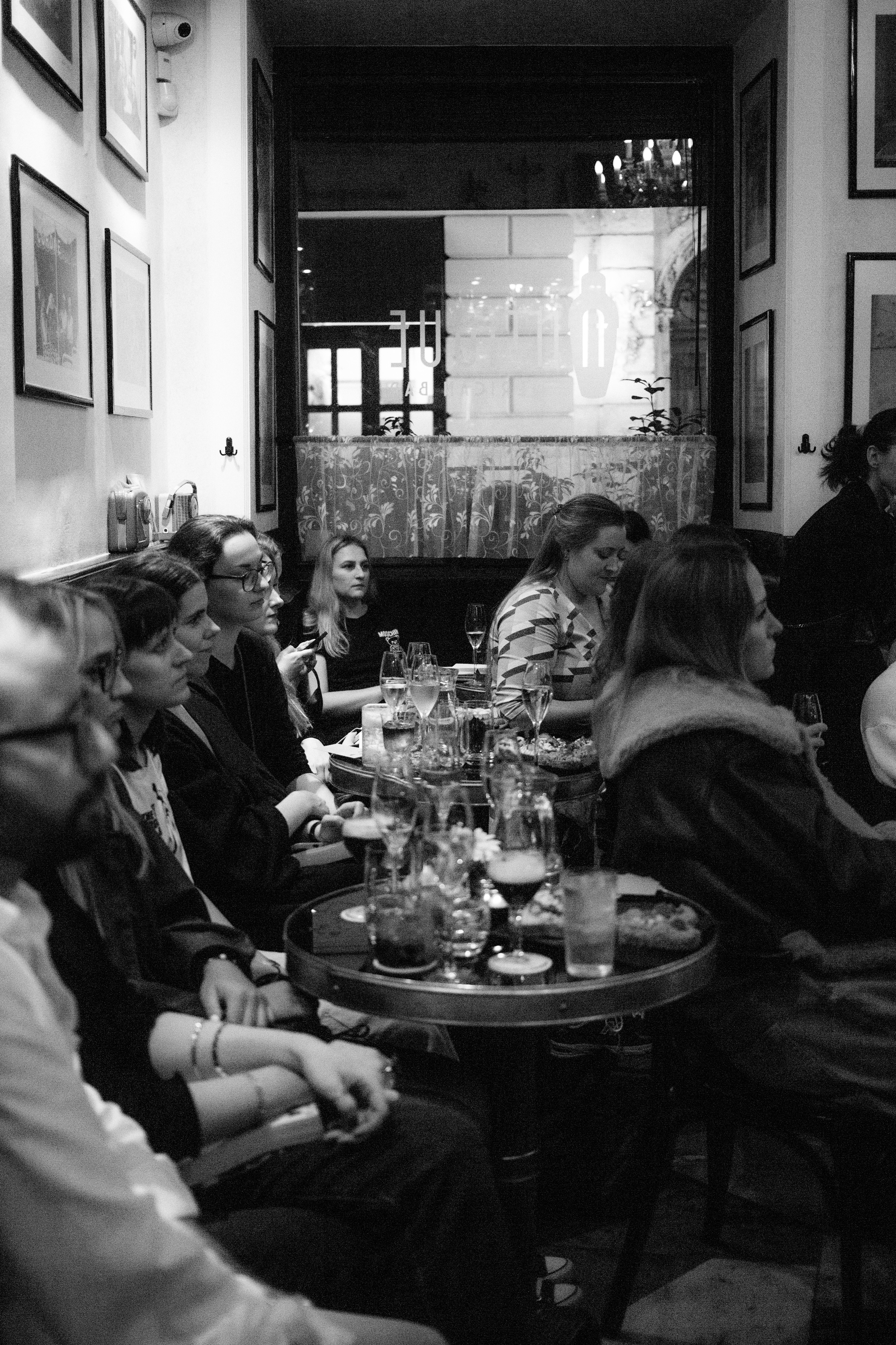 Spoločnosť hostí pri stoloch v Antique American Bar